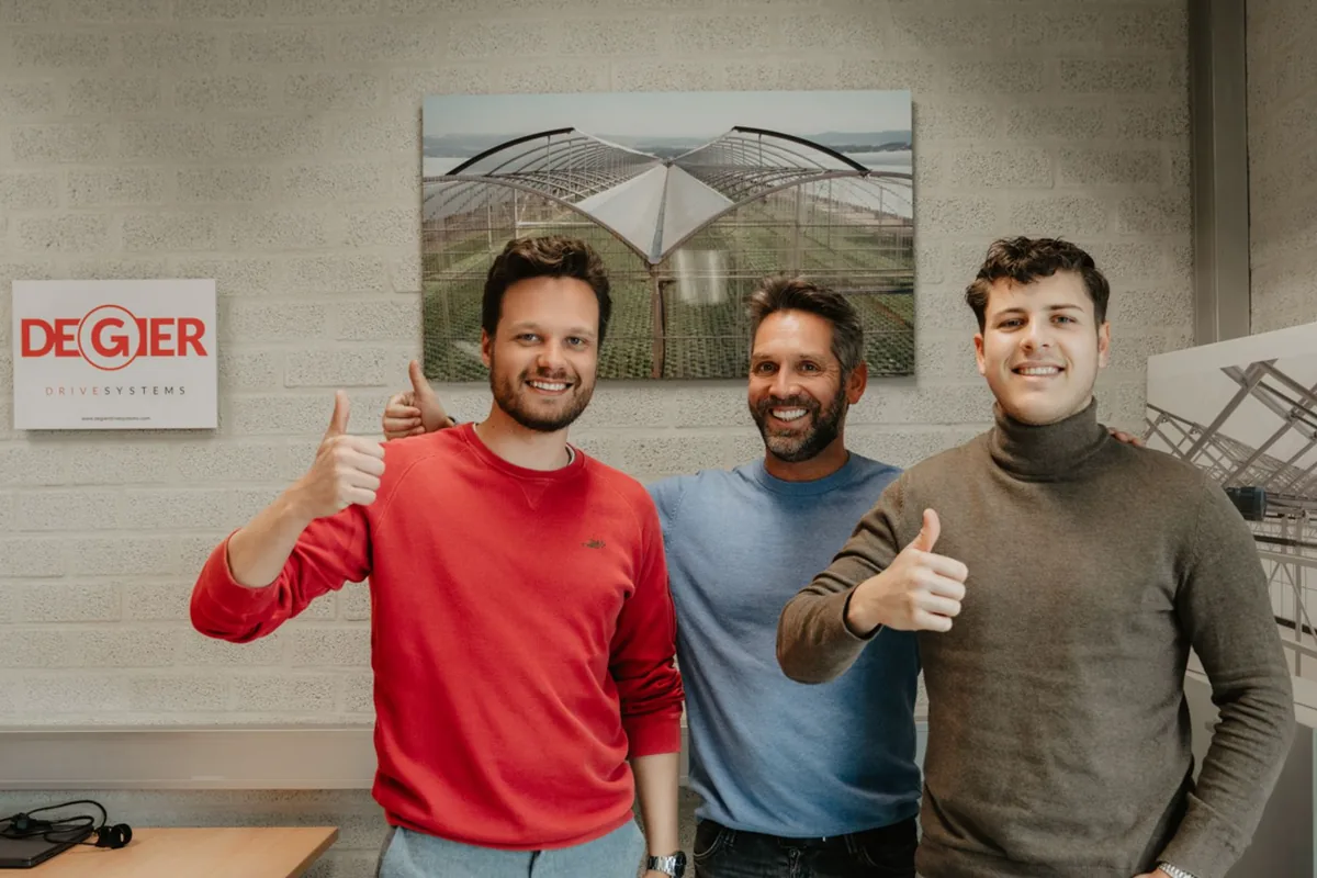 Drie medewerkers geven een duim omhoog bij De Gier Drive Systems in Wateringen