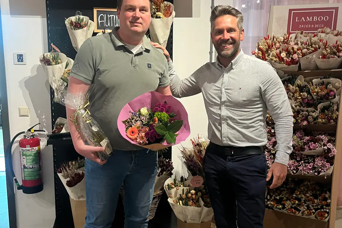 Twee mannen op een beursstand met droogbloemen en boeketten